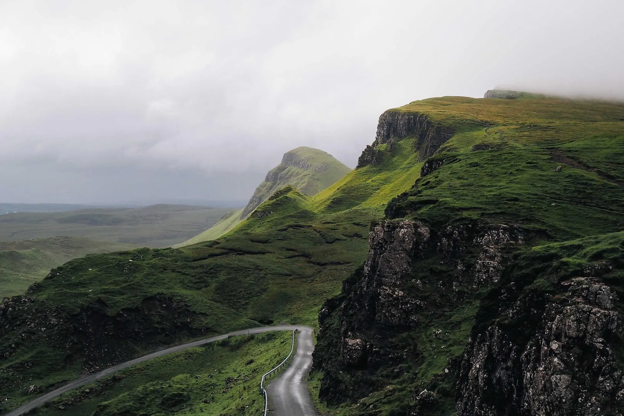 Green coastal cliffs with a winding path along the edge