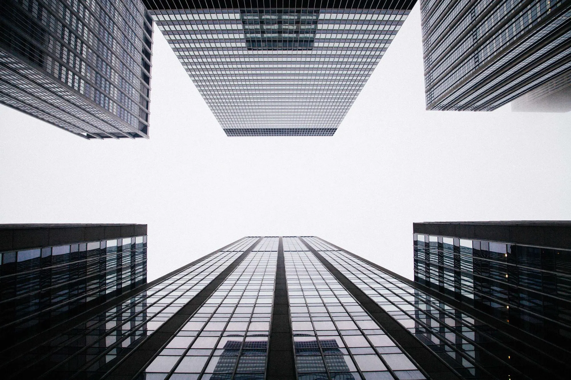 Glass towers seen from street level, looking straight up