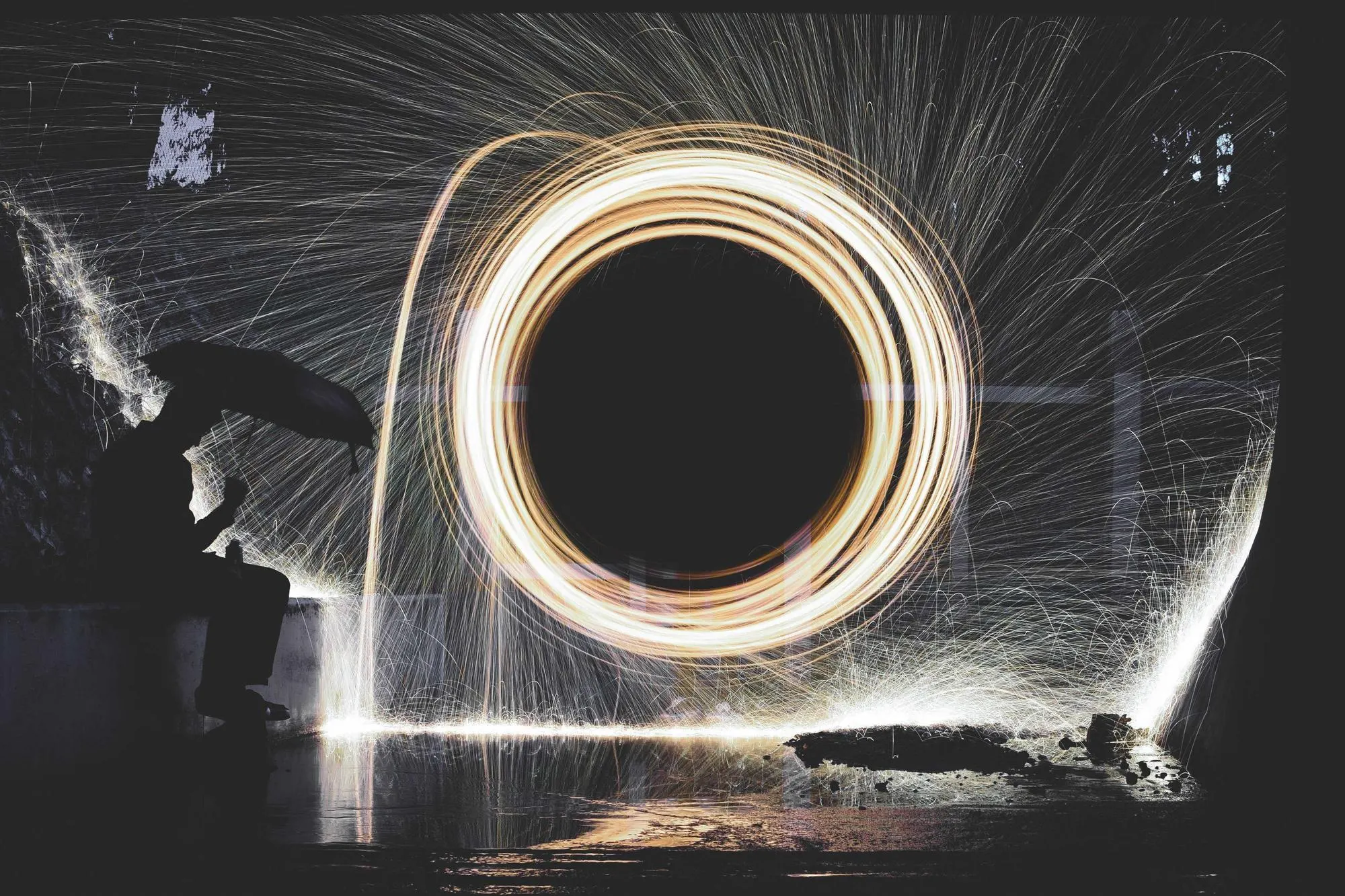 Long-exposure ring of sparks spinning in a dark tunnel
