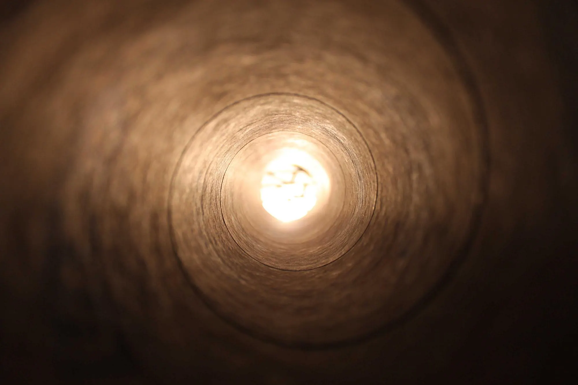 Warm light glowing through a round opening in the dark