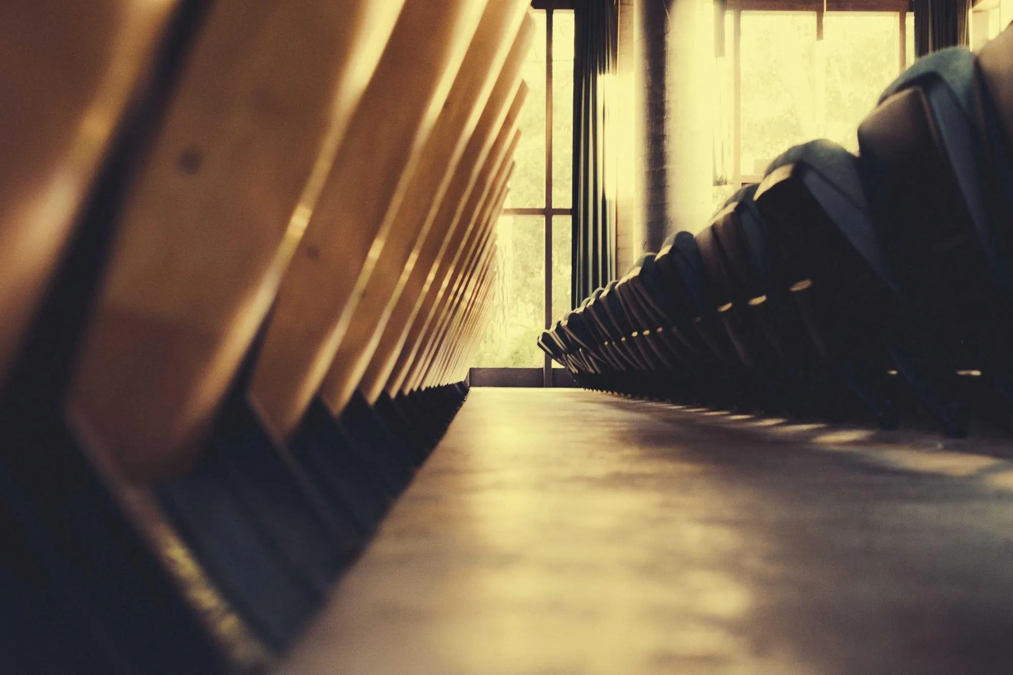 Rows of empty wooden seats in warm light