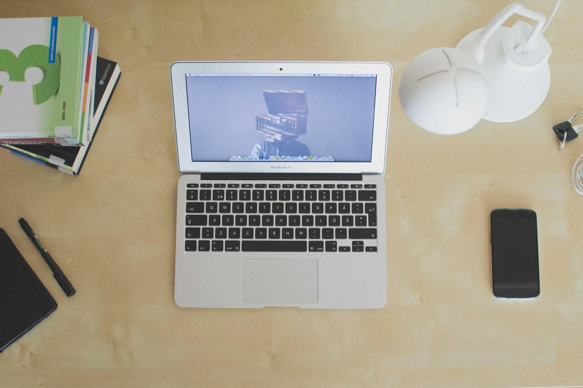 A tidy desk with a laptop, notebook and phone